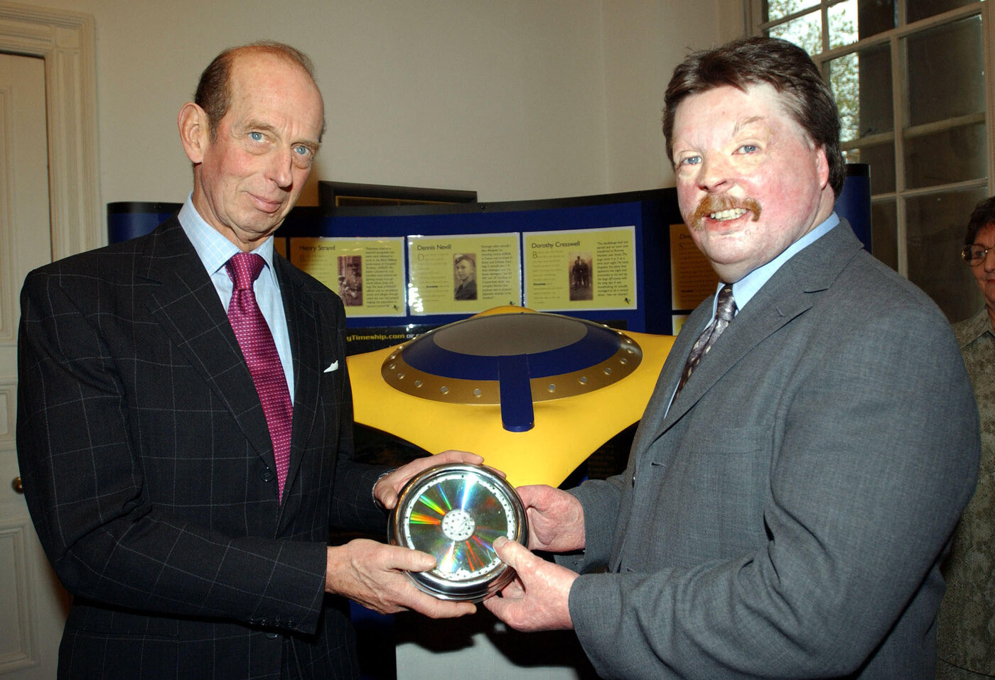 November 2001 - the first Odyssey Timeship records, on disc in a sealed presentation case, are handed to HRH the Duke of Kent at the Imperial War Museum. The physical Timeship model and story display boards stand behind.